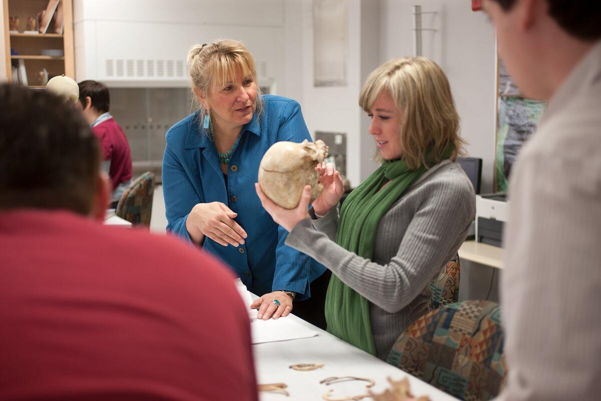 Student holding and examining a skull.