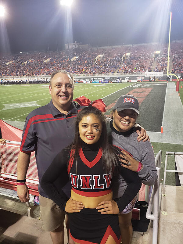 Photo of family and cheerleader at Sam Boyd Stadium