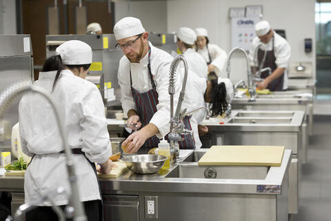 Chefs working at a prep station.
